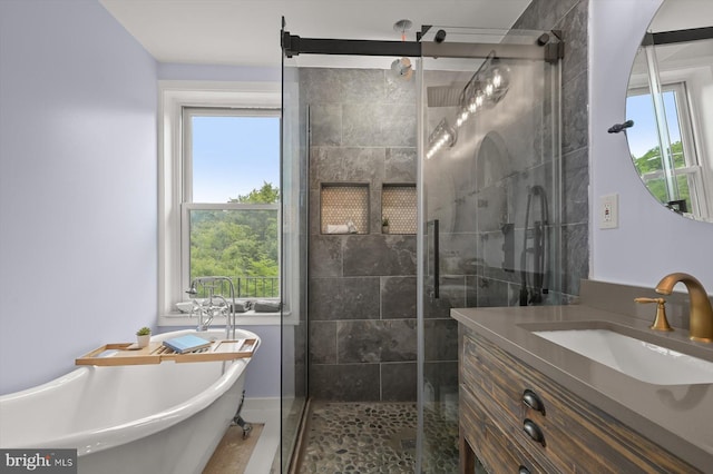 bathroom with a stall shower, a freestanding tub, and vanity