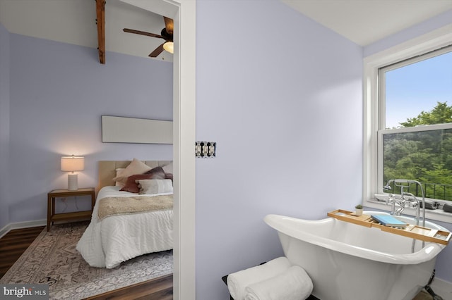 bedroom featuring wood finished floors, lofted ceiling, and baseboards