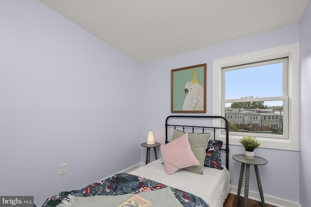 bedroom with baseboards and wood finished floors