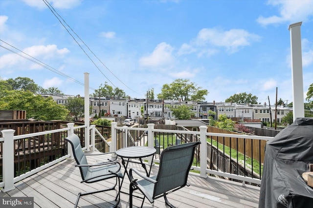 wooden deck featuring a residential view and a grill