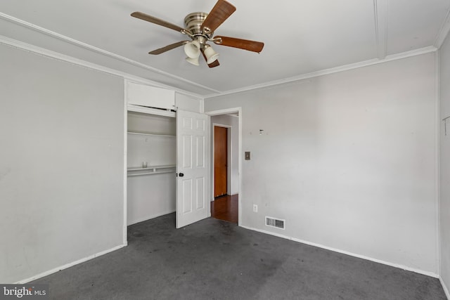 unfurnished bedroom with visible vents, baseboards, a closet, ornamental molding, and dark carpet