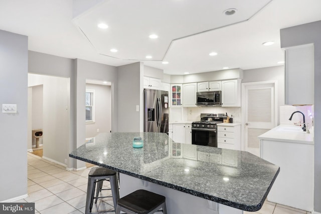 595 Tabernacle Rd, Medford, NJ 08055 - kitchen featuring appliances with stainless steel finishes, a sink, a breakfast bar area, decorative backsplash, and light tile patterned flooring