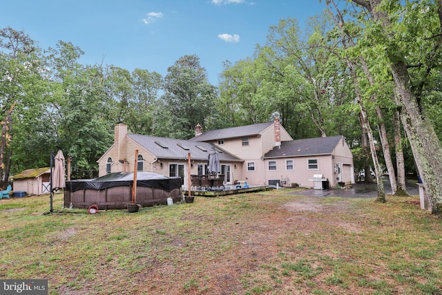 595 Tabernacle Rd, Medford, NJ 08055 - rear view of house featuring a shed, an attached garage, an outbuilding, a wooden deck, and a yard