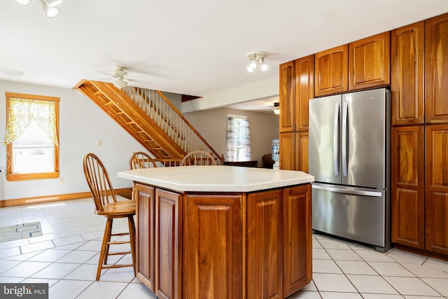 kitchen with freestanding refrigerator, light tile patterned flooring, and ceiling fan