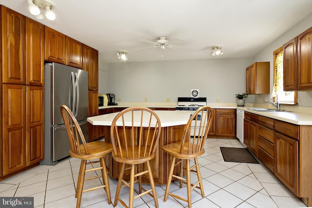 kitchen with a ceiling fan, white appliances, light countertops, a sink, and light tile patterned floors