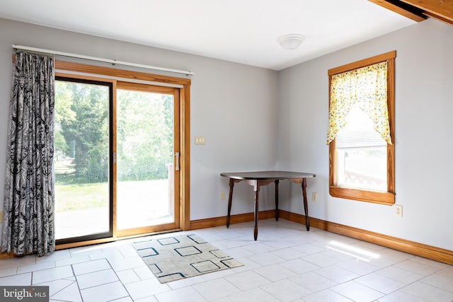 doorway featuring baseboards and tile patterned flooring
