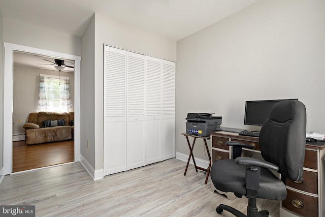 office area with baseboards, baseboard heating, and light wood finished floors