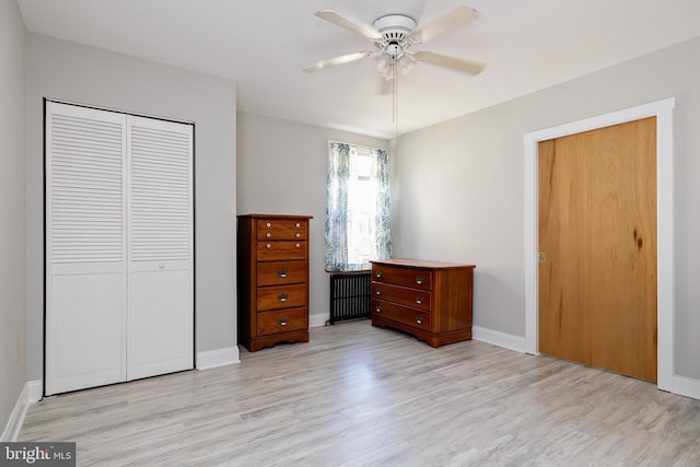 bedroom with a closet, light wood finished floors, and baseboards
