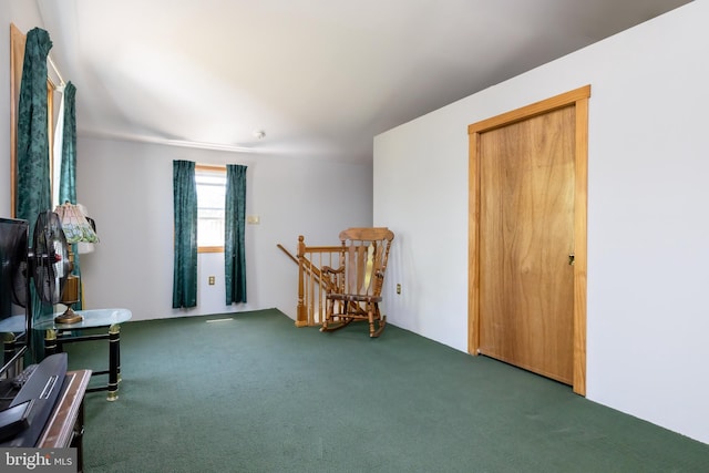 sitting room featuring carpet flooring and an upstairs landing