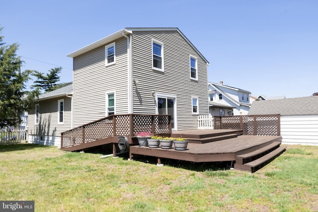 rear view of house with a yard and a deck
