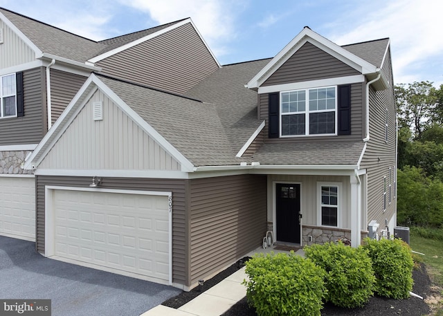 807 Anthony Dr, Harrisburg, PA 17111 - view of front of house featuring a shingled roof, board and batten siding, central air condition unit, driveway, and an attached garage