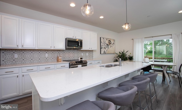 807 Anthony Dr, Harrisburg, PA 17111 - kitchen with appliances with stainless steel finishes, a sink, tasteful backsplash, white cabinetry, and a breakfast bar