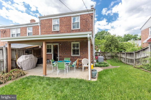 263 Medwick Garth E, Baltimore, MD 21228 - rear view of house with brick siding, a chimney, and a patio