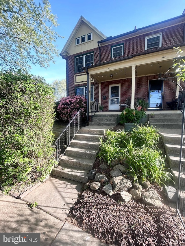 view of front of home featuring a porch and brick siding