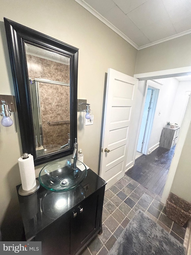 full bathroom with crown molding, a shower with shower door, and vanity
