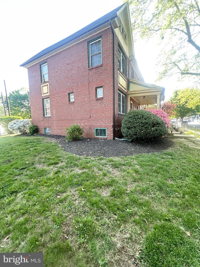 view of side of property with a yard and brick siding