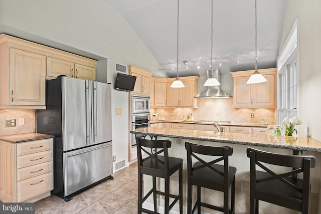 503 Colony Ct NW, Vienna, VA 22180 - kitchen with appliances with stainless steel finishes, wall chimney exhaust hood, lofted ceiling, light brown cabinets, and a kitchen bar