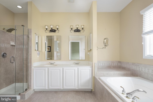 full bathroom featuring a sink, a shower stall, and a garden tub