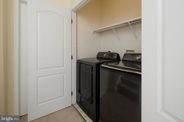 washroom with light carpet, laundry area, and washer and dryer