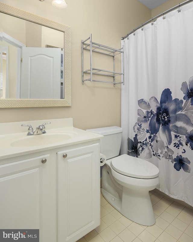 bathroom featuring tile patterned floors, vanity, toilet, and curtained shower