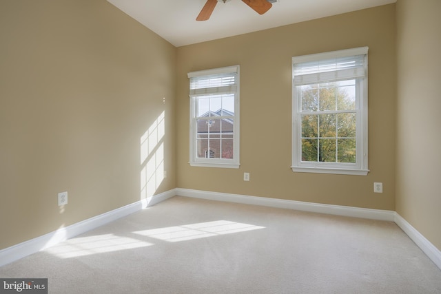 empty room with baseboards, a ceiling fan, and a wealth of natural light