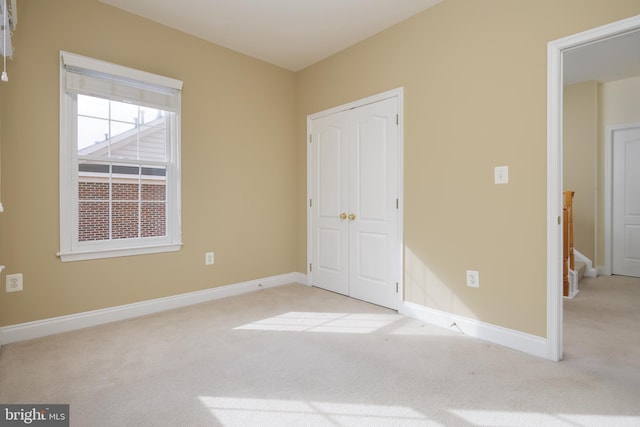 unfurnished bedroom featuring carpet floors, baseboards, and a closet