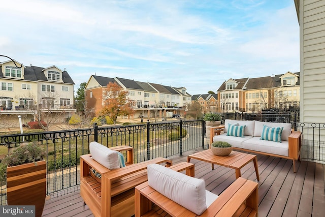 wooden terrace featuring an outdoor living space and a residential view