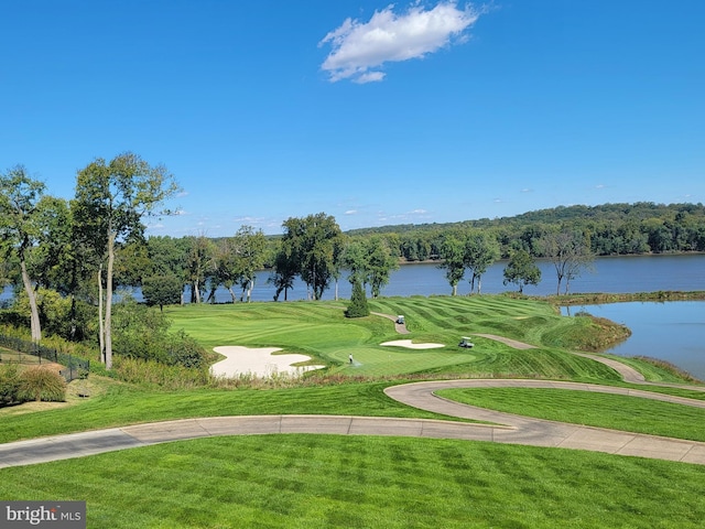 view of community featuring a lawn, a water view, and golf course view