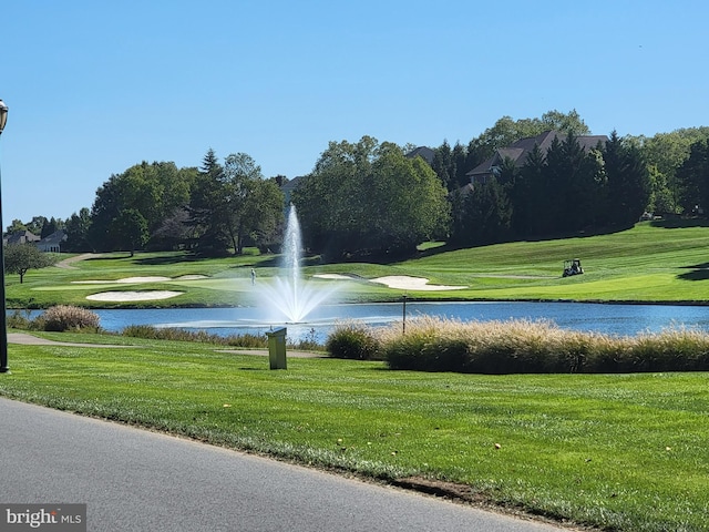 view of property's community featuring a water view, a yard, and golf course view