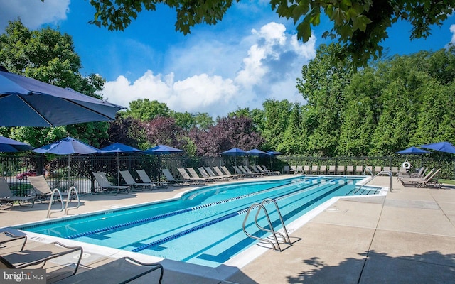 pool with a patio and fence