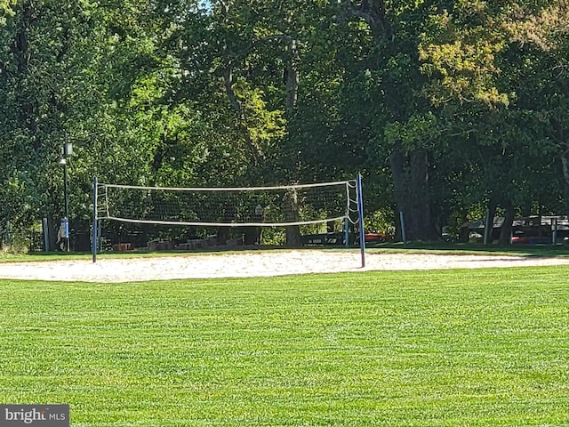 view of property's community with a yard and volleyball court