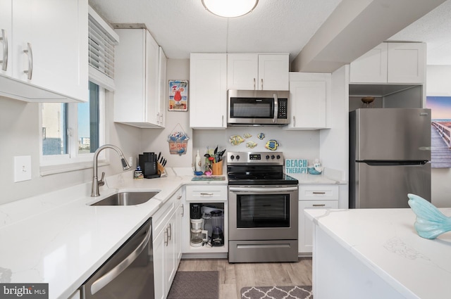 4711 Coastal Hwy Unit 441, Ocean City, MD 21842 - kitchen with white cabinets, stainless steel appliances, a sink, and light wood-type flooring