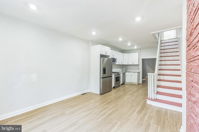 kitchen featuring light countertops, recessed lighting, appliances with stainless steel finishes, and light wood-style flooring