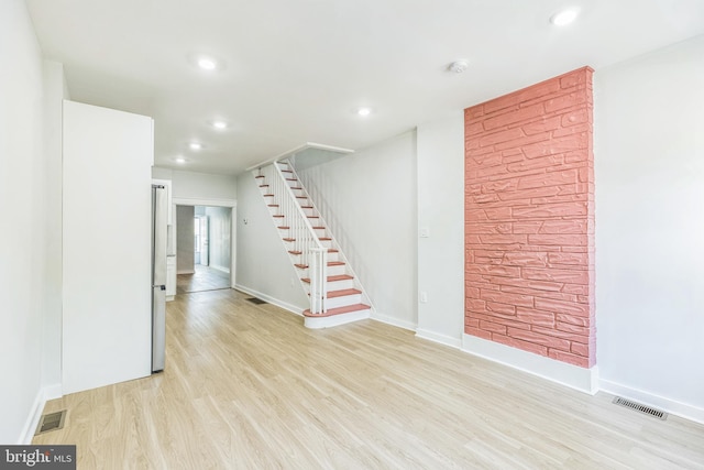 unfurnished living room featuring visible vents, baseboards, stairway, recessed lighting, and light wood finished floors