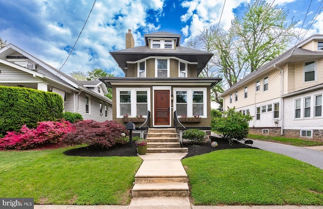 traditional style home with a front yard, entry steps, and a chimney