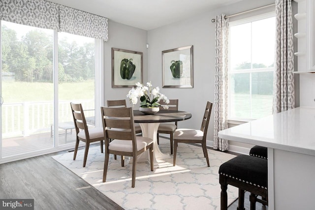 dining area with light wood-type flooring, baseboards, and plenty of natural light