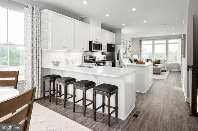 kitchen with a sink, a center island, stainless steel appliances, recessed lighting, and a peninsula