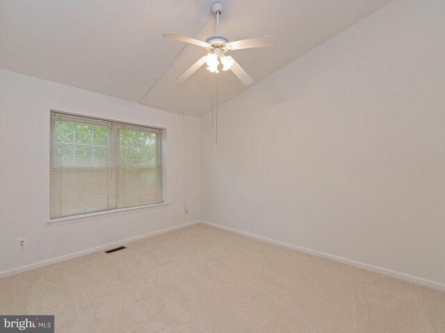 spare room with visible vents, a ceiling fan, baseboards, and light carpet