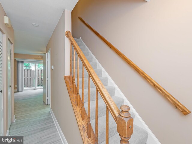 staircase featuring baseboards and wood finished floors