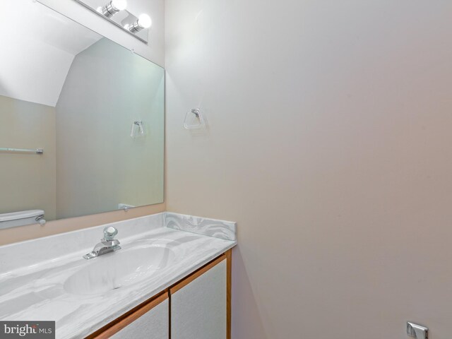 bathroom featuring vaulted ceiling and vanity