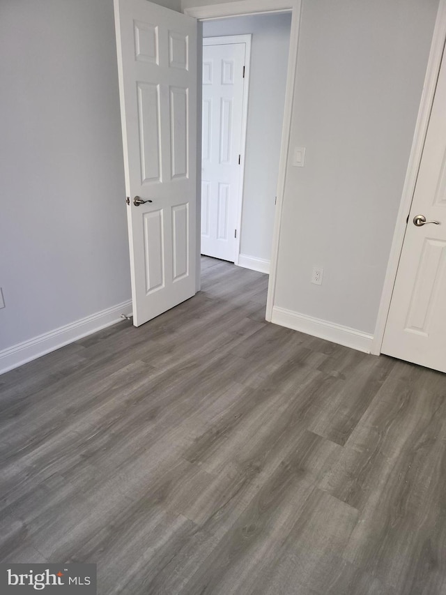4800 C St SE Unit 104, Washington, DC 20019 - unfurnished bedroom featuring baseboards and dark wood-type flooring