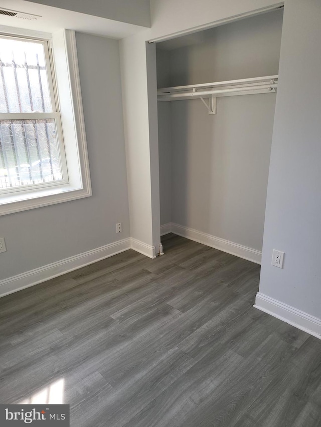 4800 C St SE Unit 104, Washington, DC 20019 - unfurnished bedroom with dark wood-style flooring, baseboards, visible vents, and a closet