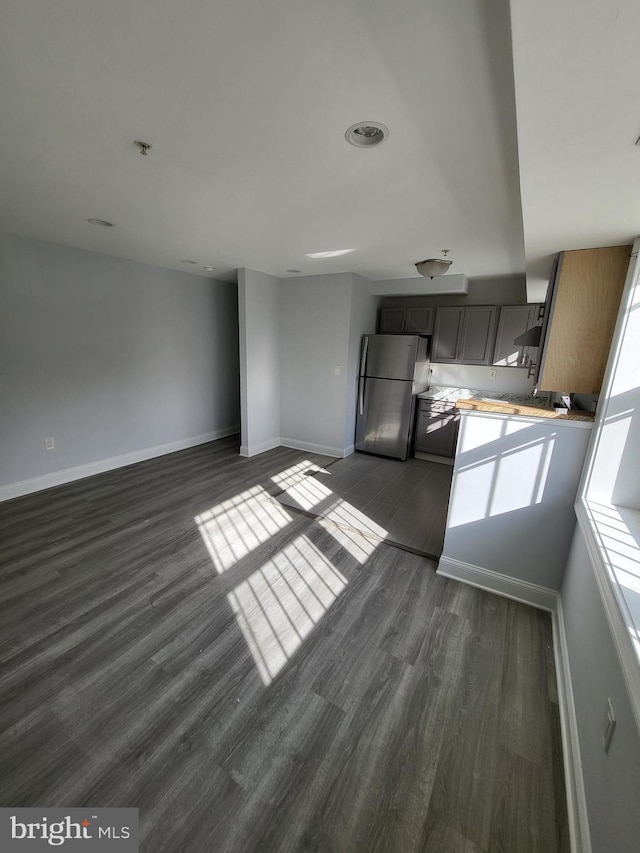 4800 C St SE Unit 104, Washington, DC 20019 - kitchen featuring light countertops, dark wood finished floors, freestanding refrigerator, baseboards, and open floor plan
