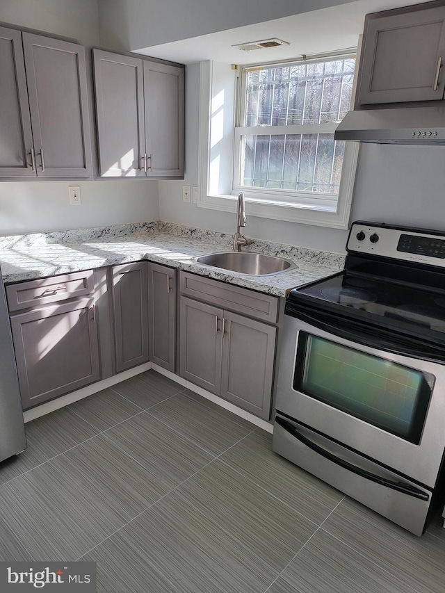 4800 C St SE Unit 104, Washington, DC 20019 - kitchen with a sink, gray cabinets, electric range, and wall chimney exhaust hood