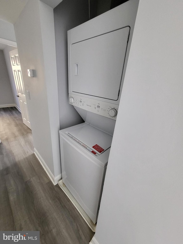4800 C St SE Unit 104, Washington, DC 20019 - clothes washing area with baseboards, laundry area, stacked washing maching and dryer, and wood finished floors