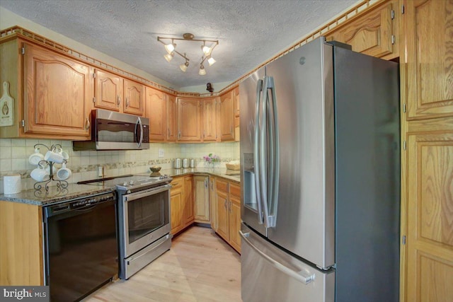 kitchen with backsplash, a textured ceiling, stone counters, stainless steel appliances, and light wood-style flooring