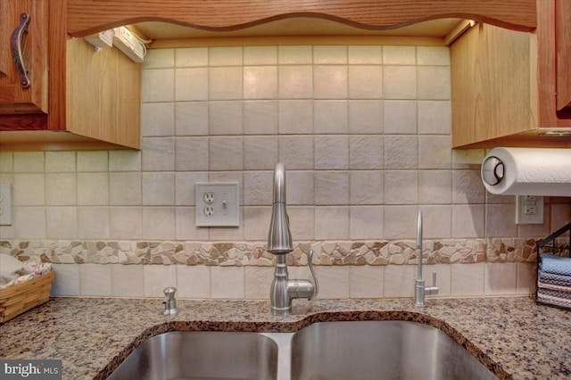 details featuring light stone counters, a sink, light brown cabinetry, and tasteful backsplash
