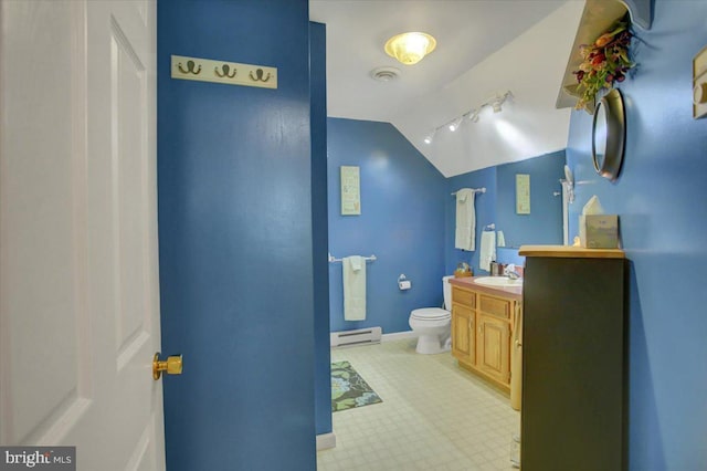 bathroom featuring vanity, toilet, baseboards, baseboard heating, and vaulted ceiling