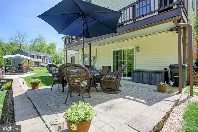 view of patio featuring outdoor dining space and a balcony