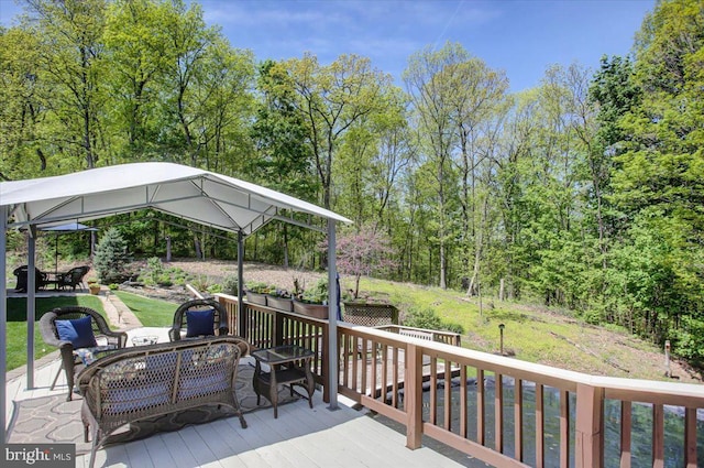 wooden terrace featuring an outdoor hangout area and a gazebo